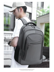 Side view of dark grey business backpack with mesh pocket and padded handle on a model
