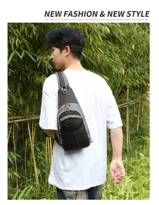 Outdoor close-up of dark grey hiking sling bag with adjustable strap in bamboo forest