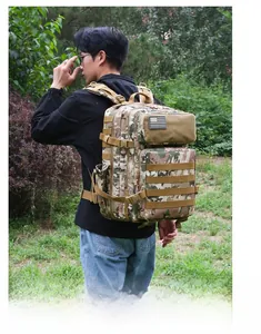 Detail of multicam tactical backpack with MOLLE system and US flag patch in outdoor setting