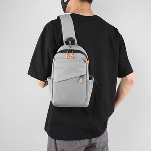 Sac bandoulière minimaliste gris clair avec détail zip orange porté par un homme