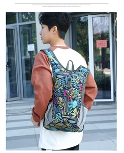 Outdoor waterproof cycling backpack with tropical leaf prints shown on a male model back