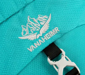 Detailed close-up of 60L hiking backpack showing turquoise ripstop fabric and logo