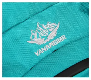 Detail of teal ripstop fabric with silver mountain logo embroidery on the backpack