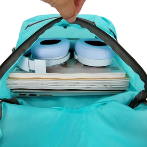 Spacious interior of teal ultralight packable backpack holding laptop and headphones