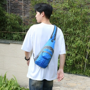 Blue waterproof hiking daypack sling bag for men worn outdoors by model in white tshirt