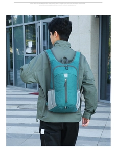 Detail of teal waterproof nylon backpack with reflective strips and mesh side pockets