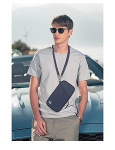 Outdoor shot of a grey RFID neck pouch with long strap worn by a male model