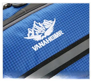 Detail of blue textured fabric with VANAHEIMR embroidery and grey reflective stripe