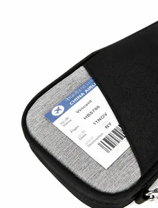 Detail shot of the front slot pocket on a grey travel passport bag holding a boarding pass