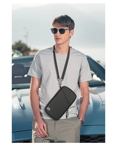 Outdoor shot of a black waterproof travel passport holder with an adjustable neck strap