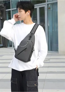 Detail of dark grey crossbody chest bag featuring earphone port and mesh side pocket
