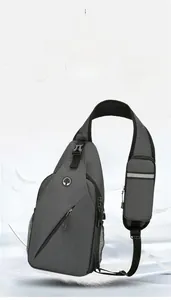 Detail of grey crossbody bag showing breathable mesh strap with a small pouch and reflector