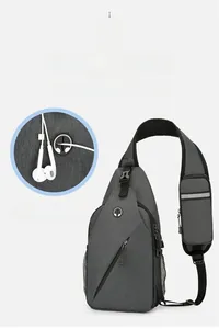Detail of grey crossbody bag featuring integrated headphone jack and mesh water bottle pocket
