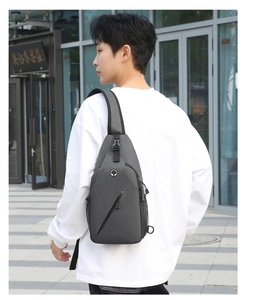Detailed view of gray lightweight cross body bag with headphone port and side mesh pocket