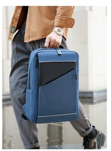 Detail of blue textured business backpack showing a black triangle zipper and reinforced handle