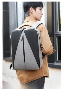 Homme portant un sac à dos business gris et noir imperméable avec design géométrique