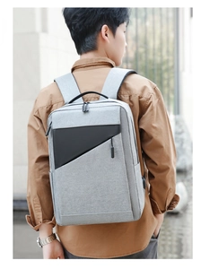 Grey canvas backpack detail showing sleek geometric design and side USB charging port