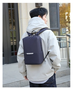 Dettaglio dello zaino blu navy con doppie cerniere metalliche e striscia riflettente di sicurezza