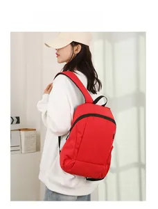 Vue latérale d'un sac à dos de sport rouge porté par une femme dans un décor de studio