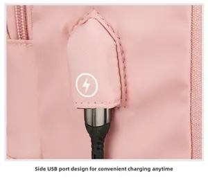 Detailansicht des rosa Reiserucksacks mit seitlichem USB-Ladeanschluss und Ladekabel