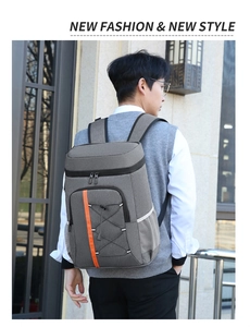 Detail of grey insulated backpack with orange straps and front bungee storage system