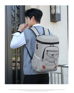 Detail of grey waterproof picnic backpack showing front zipper pocket and bungee cords