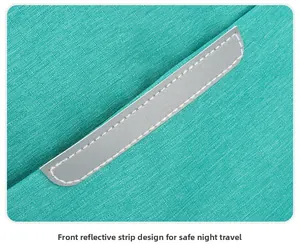Close-up of the front reflective safety strip on the teal water-resistant backpack fabric