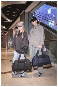 Detalle de bolsas de viaje grandes en negro y azul marino para deporte y fitness activo