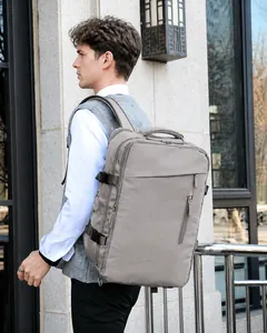 Light khaki travel backpack with multi-layer zippers shown on male model outdoors