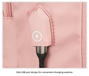 Détail du port de charge USB externe avec couvercle rose sur le sac à dos de voyage
