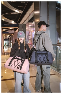 Detalle de bolsas de viaje grandes en rosa y gris con material de nailon y correas de deporte