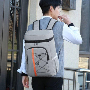 Insulated grey thermal backpack with orange details shown on a person for outdoor picnics