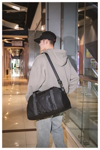 Detalle de bolsa de viaje negra impermeable con cordones elásticos y correa ajustable
