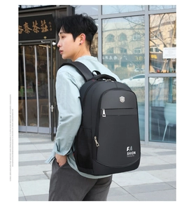 Outdoor view of a man wearing a large black oxford business backpack with side pockets