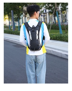 Outdoor hydration backpack with elastic storage system shown on model during cycling