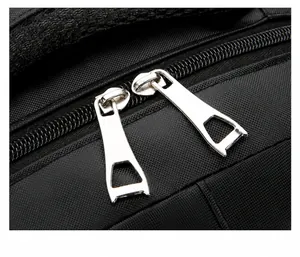 Detail of the durable dual metal zippers on a black textured nylon business backpack