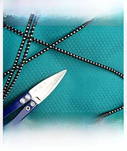 Close-up of tear-resistant honeycomb nylon fabric with scissors and elastic cord
