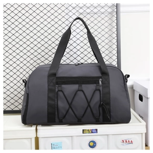 Detalle de bolsa de viaje gris oscuro con bolsillo de cremallera y correas elásticas