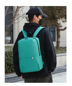 Detail eines minimalistischen minzgrünen Rucksacks mit schwarzen Reißverschlüssen