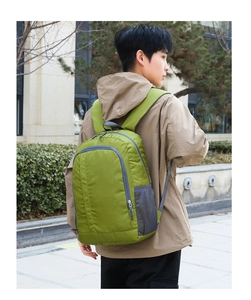 Detail of grass green outdoor backpack showing durable nylon fabric and mesh side pocket