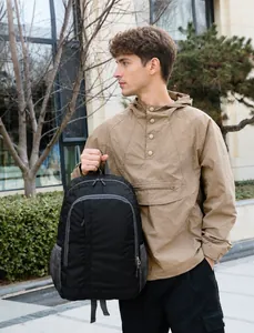 Close-up of black durable fabric backpack featuring mesh side pocket and metallic zippers