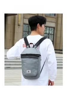 Outdoor waterproof gray backpack for men featuring multi-layer zippers and side view on model