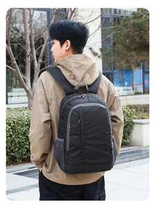Outdoor sports backpack in black and grey mesh detail shown on model in urban setting