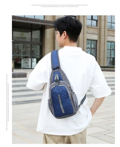 Outdoor crossbody bag detail showing adjustable wide shoulder strap and blue nylon fabric