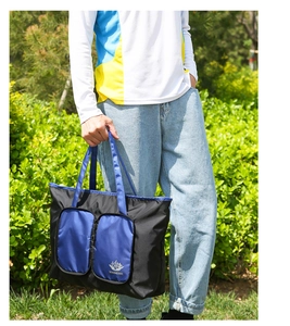 Détail du sac de voyage pliable montrant le tissu oxford noir et le logo bleu Vanaheimr