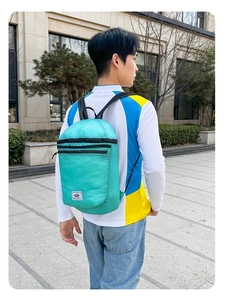 Detail view of the lightweight mint green foldable backpack with mountain logo and mesh texture