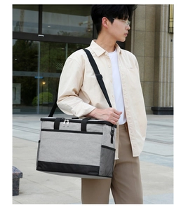 Photo lifestyle d'un sac isotherme gris avec bandoulière large et poche filet latérale
