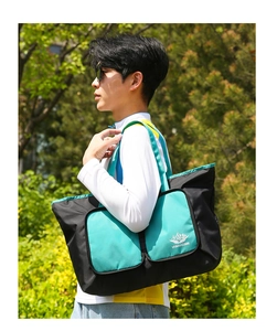 Détail du sac de voyage pliable en nylon avec poches latérales et logo imprimé