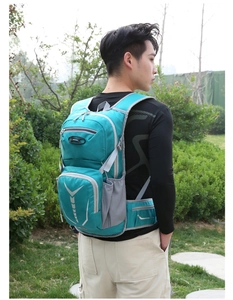 Green cycling backpack with gray mesh side pockets and reflective safety strips for outdoors