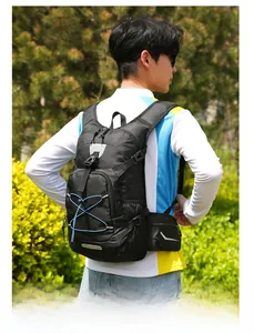 Detail of black nylon outdoor backpack featuring blue bungee cords and reflective strips